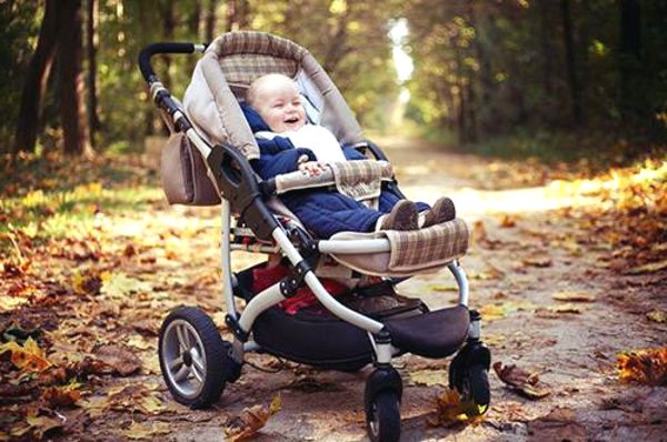 Малыш в коляске в парке осенью